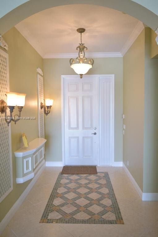 tiled entrance foyer featuring crown molding