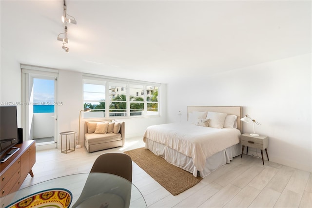 bedroom with light hardwood / wood-style flooring and rail lighting