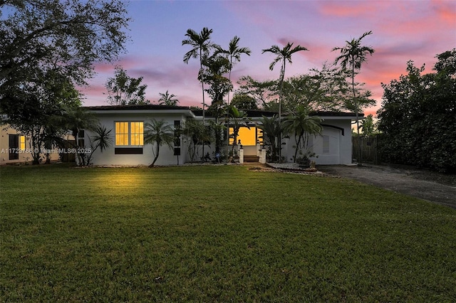 ranch-style house featuring a lawn and a garage