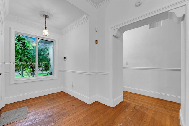 empty room with hardwood / wood-style floors and ornamental molding