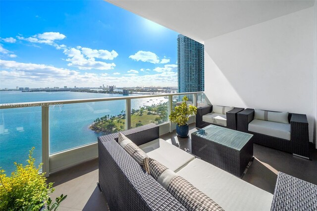 balcony featuring an outdoor living space and a water view