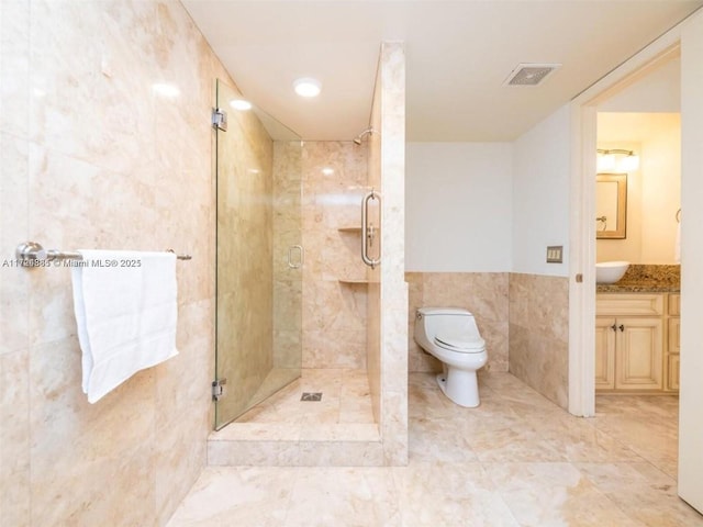 bathroom featuring toilet, vanity, tile walls, and walk in shower