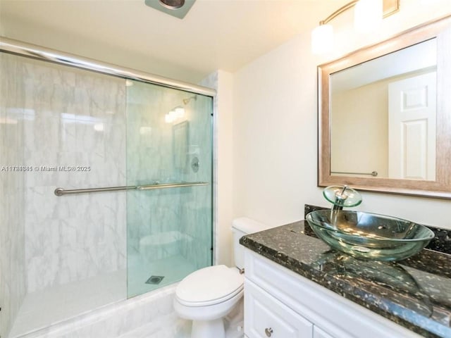 bathroom with vanity, toilet, and a shower with shower door