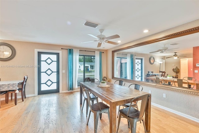 dining space with ceiling fan and light hardwood / wood-style flooring