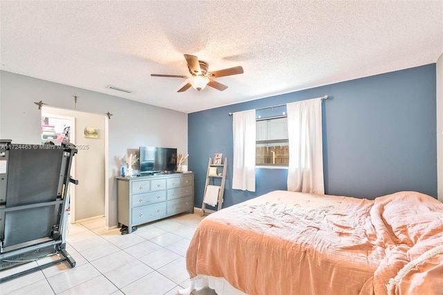 bedroom with a textured ceiling, ceiling fan, and light tile patterned flooring