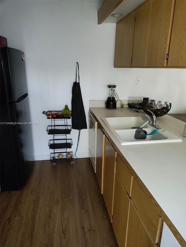 kitchen featuring sink, black fridge, dishwasher, and dark wood-type flooring