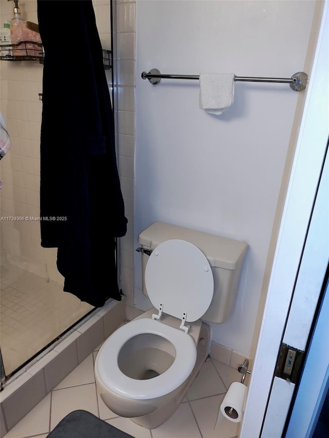 bathroom featuring an enclosed shower, tile patterned floors, and toilet