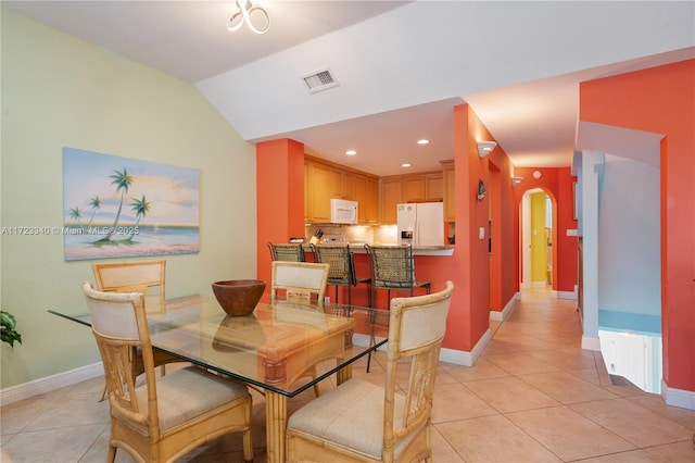 tiled dining space with vaulted ceiling