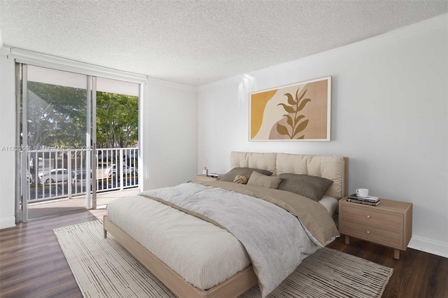 bedroom with a textured ceiling, dark wood-type flooring, access to outside, and expansive windows