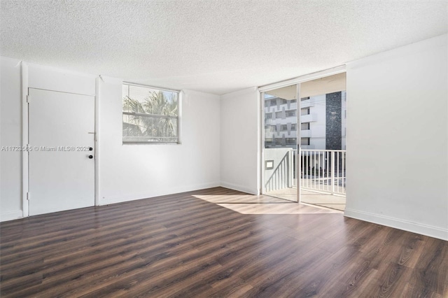 unfurnished room featuring dark wood-type flooring, a textured ceiling, and expansive windows