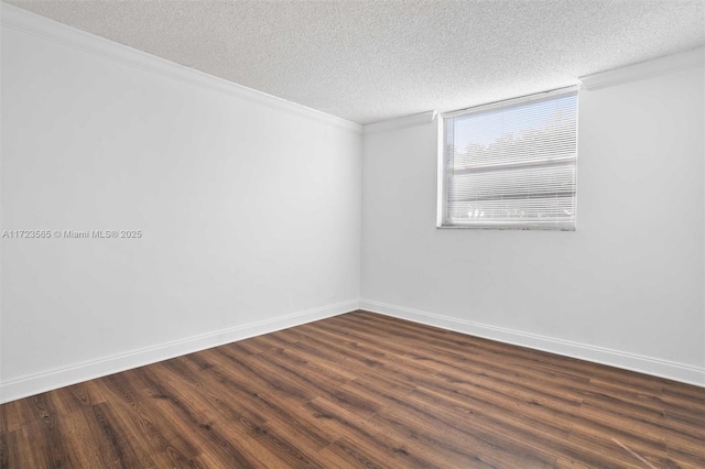 spare room featuring a textured ceiling, ornamental molding, and dark hardwood / wood-style floors