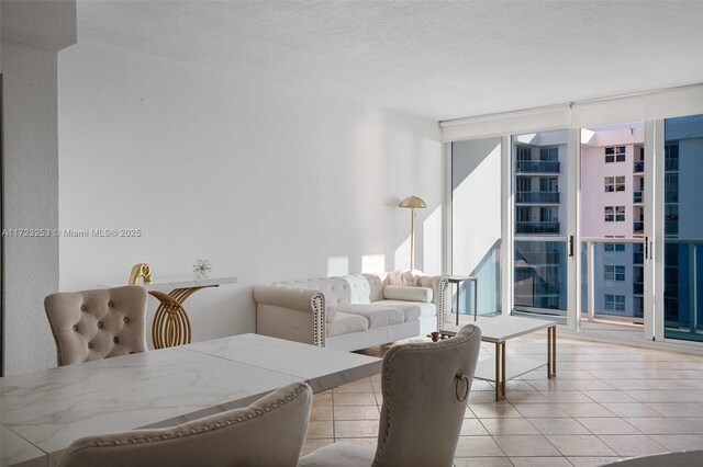 living room featuring floor to ceiling windows, a textured ceiling, and light tile patterned floors