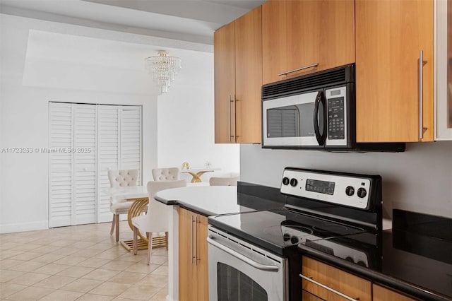 kitchen featuring light tile patterned floors, a notable chandelier, and electric stove