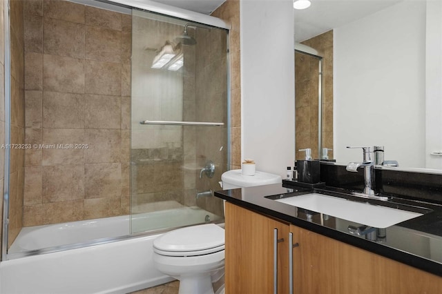 full bathroom featuring vanity, toilet, and combined bath / shower with glass door