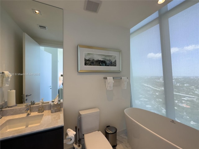 bathroom featuring a bathtub, vanity, and toilet