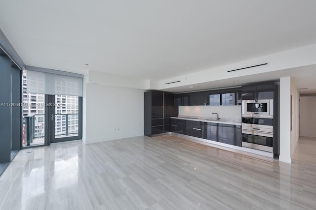 unfurnished living room with floor to ceiling windows and sink