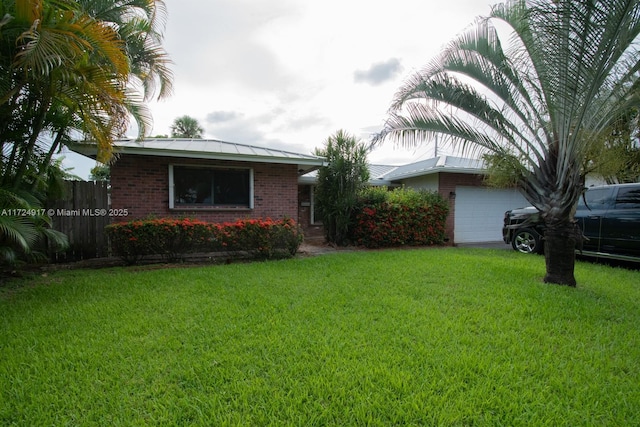 single story home featuring a garage and a front lawn