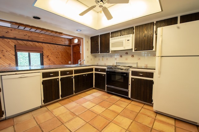 kitchen featuring wood walls, ceiling fan, light tile patterned flooring, and white appliances