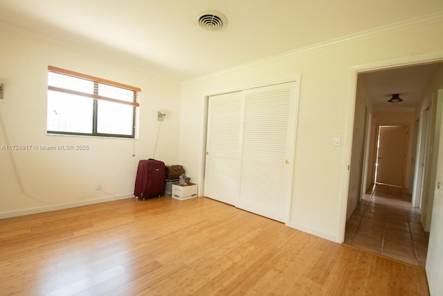 unfurnished bedroom featuring hardwood / wood-style flooring, a closet, and ornamental molding