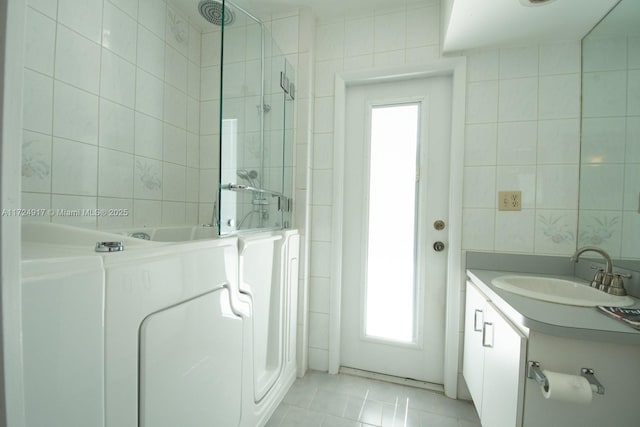 bathroom with tile patterned flooring, vanity, and tile walls