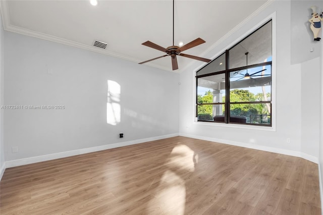 unfurnished room featuring light hardwood / wood-style floors, vaulted ceiling, and crown molding