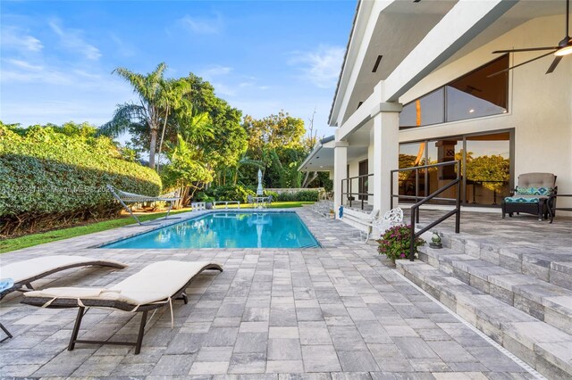 view of swimming pool with a patio and ceiling fan