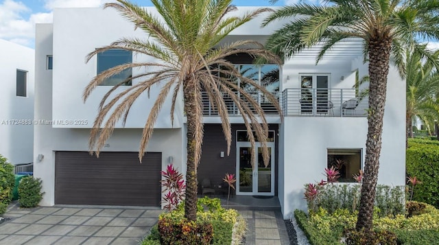 view of front of house featuring french doors, a balcony, and a garage