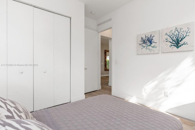 bedroom with light hardwood / wood-style flooring and a closet