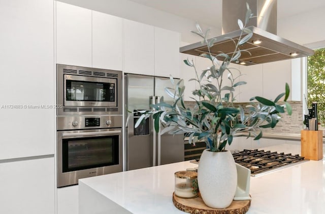 kitchen with white cabinets, island range hood, and appliances with stainless steel finishes