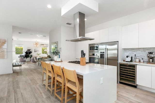 kitchen with white cabinets, beverage cooler, and island exhaust hood