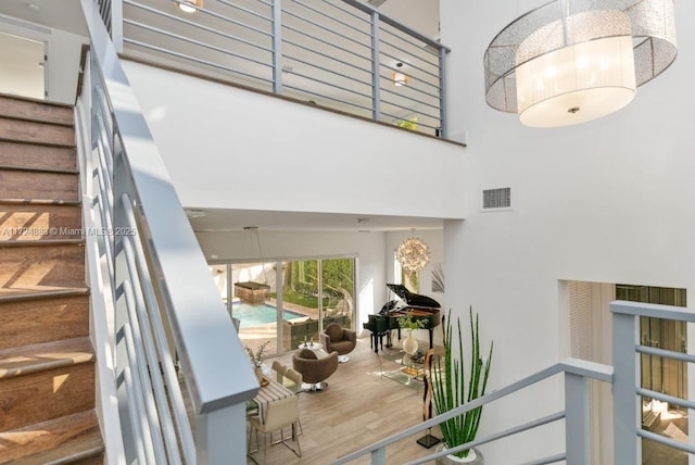 stairs featuring a towering ceiling and wood-type flooring