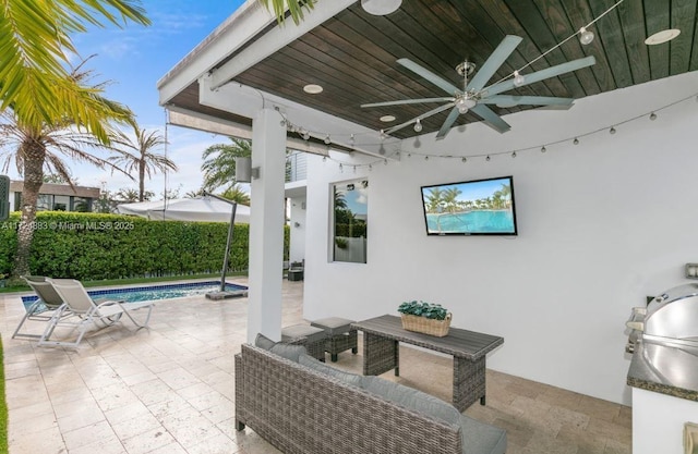 view of patio with exterior kitchen, ceiling fan, and a fenced in pool