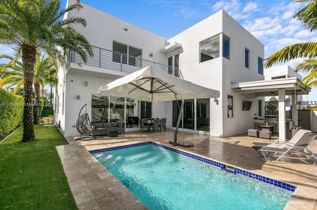 back of house featuring a balcony, a patio, and outdoor lounge area