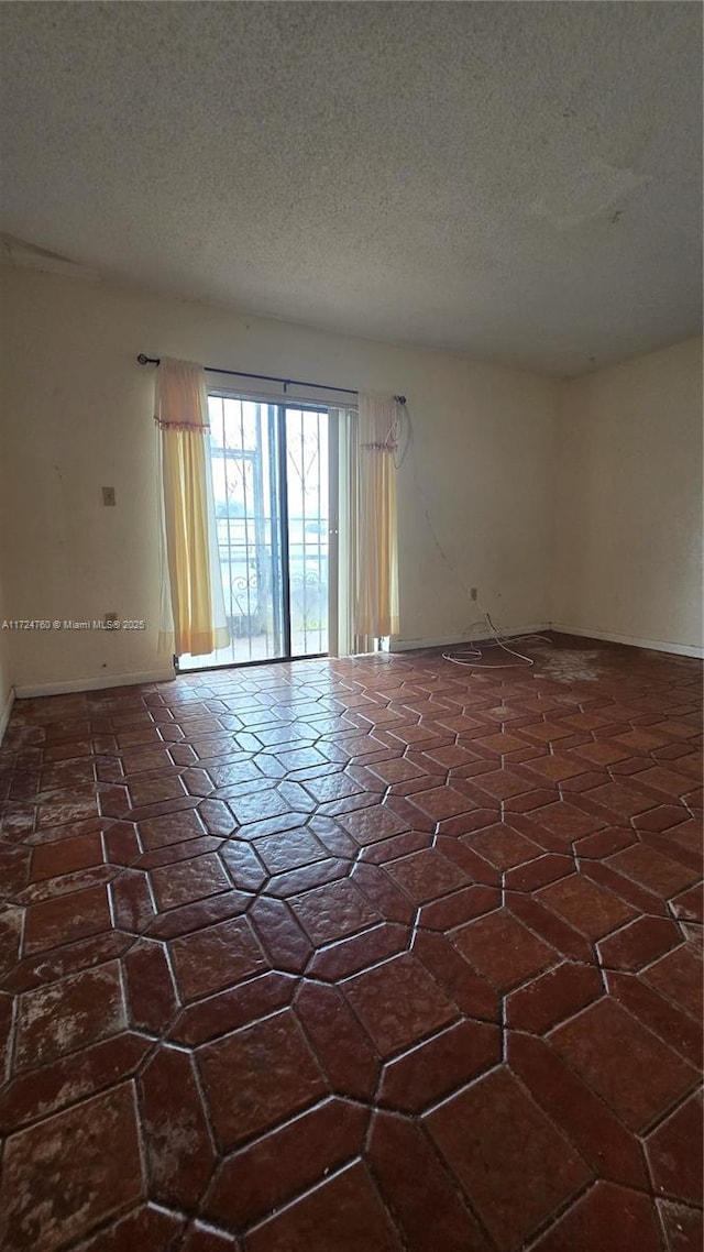 unfurnished room featuring a textured ceiling