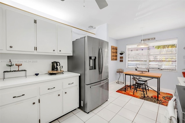 kitchen featuring ceiling fan, stainless steel fridge, light tile patterned floors, decorative light fixtures, and white cabinetry