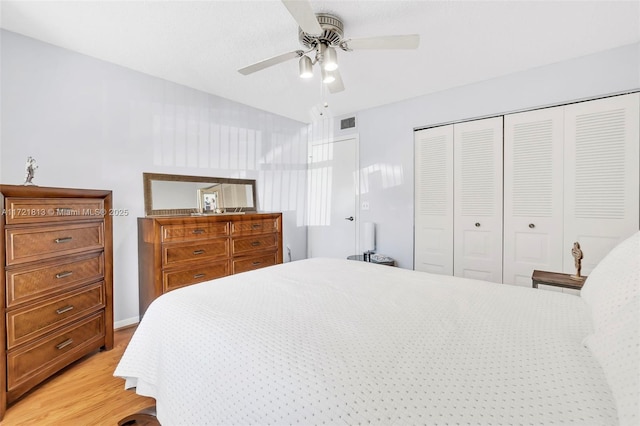 bedroom featuring ceiling fan, light hardwood / wood-style flooring, and a closet