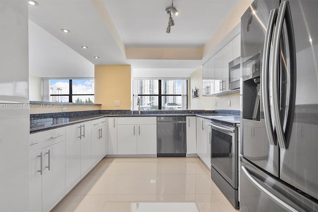 kitchen featuring stainless steel appliances, light tile patterned floors, white cabinets, and kitchen peninsula