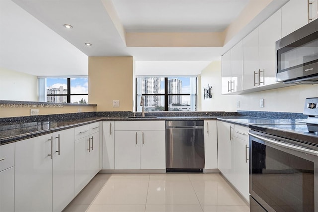 kitchen with appliances with stainless steel finishes, sink, and white cabinetry