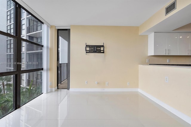 unfurnished room featuring expansive windows and light tile patterned flooring