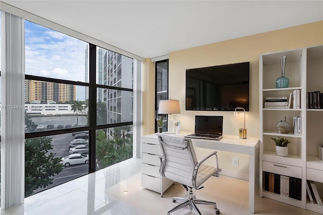 office area featuring expansive windows, light tile patterned flooring, and built in desk