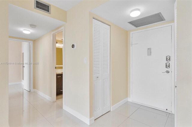 hall featuring light tile patterned floors and sink