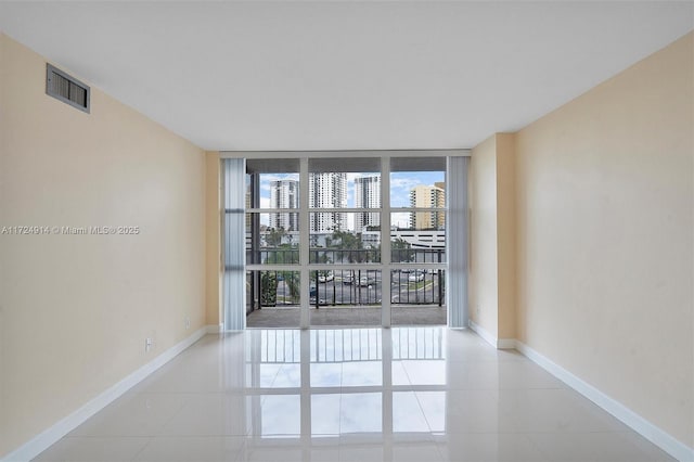 tiled spare room featuring expansive windows