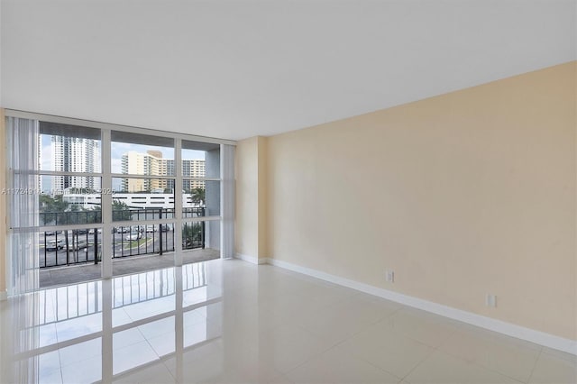 tiled spare room with a wall of windows