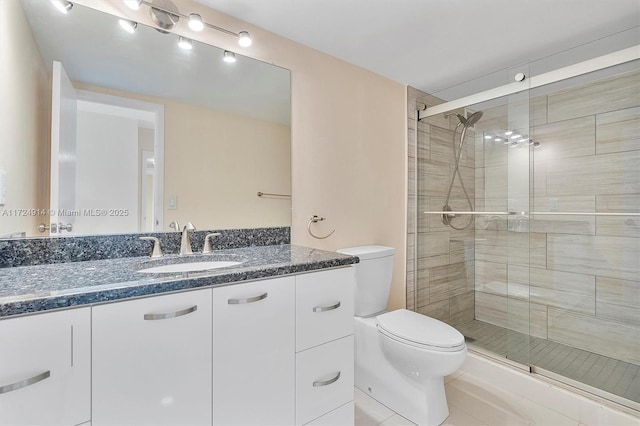 bathroom featuring walk in shower, tile patterned floors, vanity, and toilet