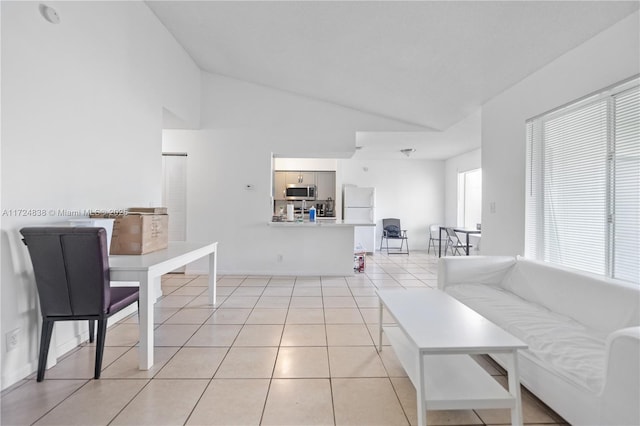 living room featuring high vaulted ceiling and light tile patterned flooring