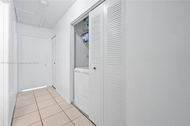 hall featuring washer / dryer and light tile patterned floors