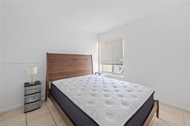 bedroom featuring light tile patterned flooring and a textured ceiling