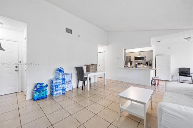 tiled living room featuring high vaulted ceiling