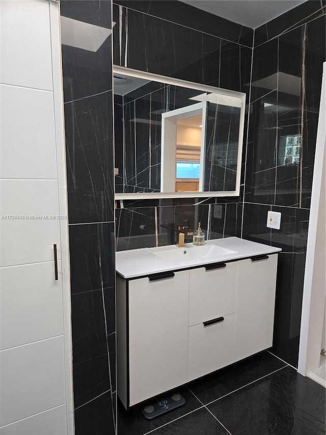 bathroom with tile walls, vanity, decorative backsplash, and tile patterned floors