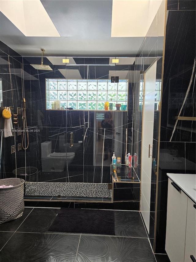 bathroom with a skylight and a shower with door